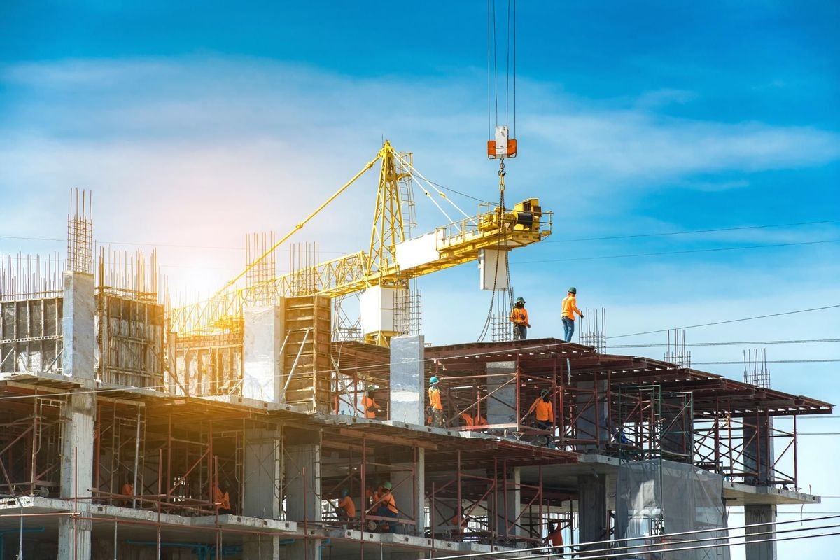 Construction site with crane, workers, and rebar, hinting at infrastructure projects.