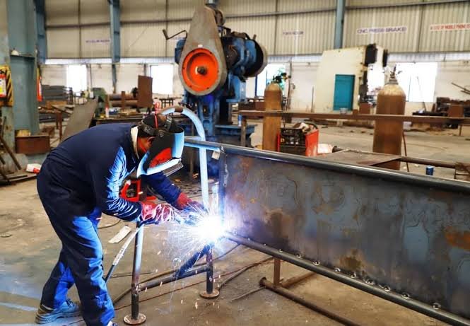 Welder working on stainless steel products in a Pune factory