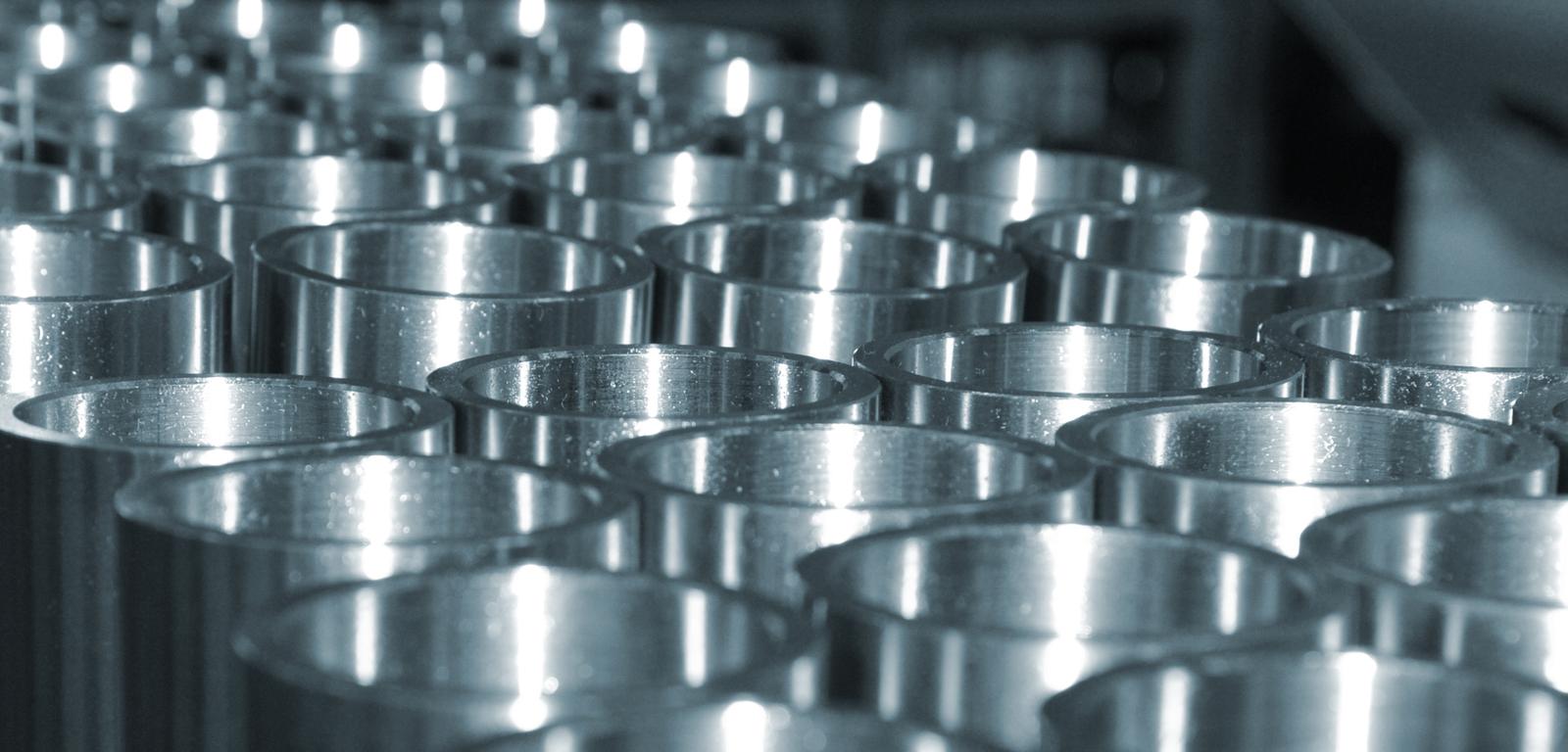 Close-up of polished duplex steel tubes in a factory setting.