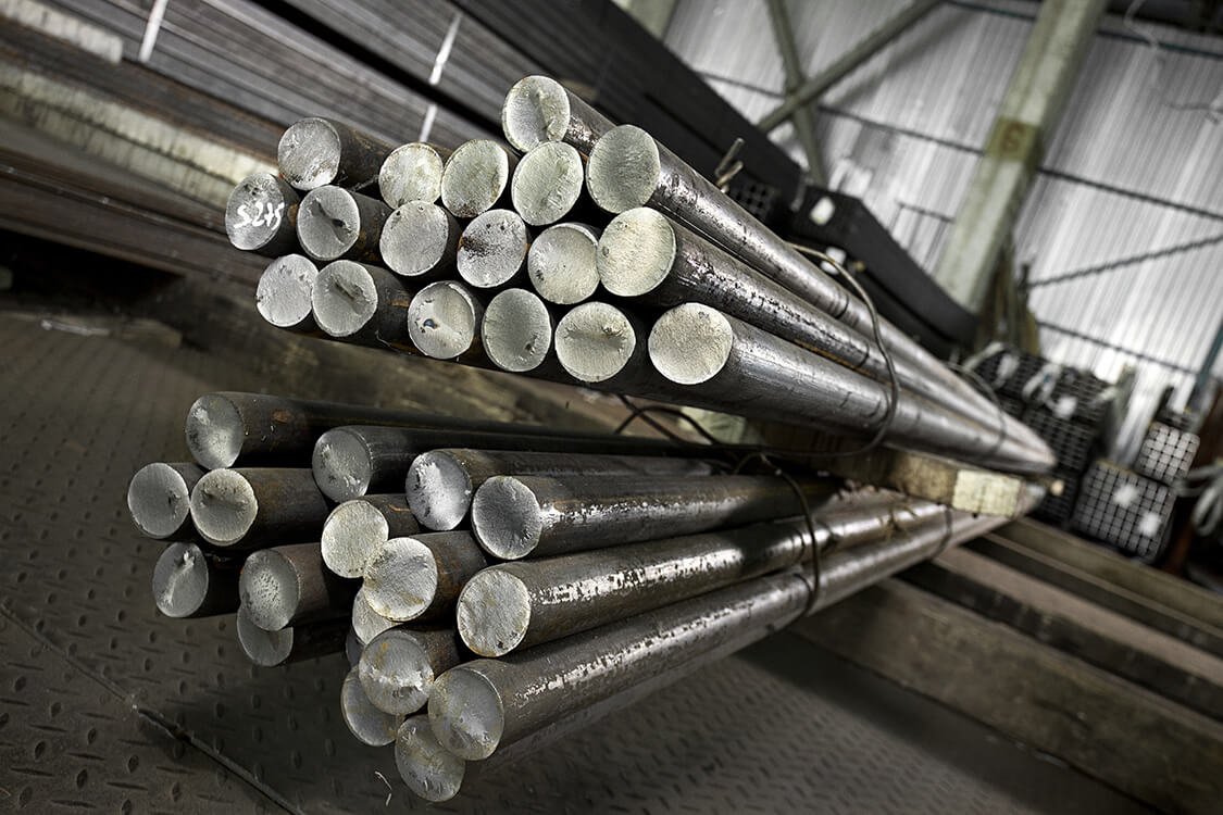 Bundles of steel bars and coils in a warehouse, suitable for industrial use.