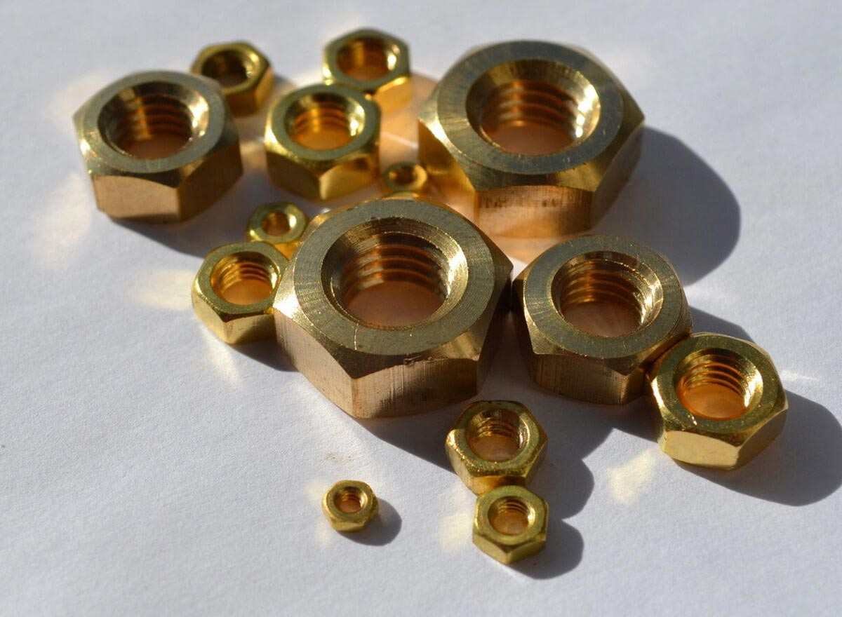 Assortment of brass nuts of varying sizes, with a gunmetal-like sheen